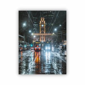 Canvas print of flinders street station clock tower from the view on elizabeth street on a rainy day.