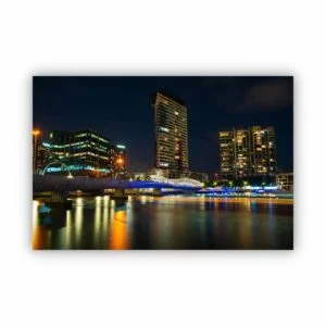 Photography of Melbourne city view at night from the Yarra River with light trail of a speed boat.