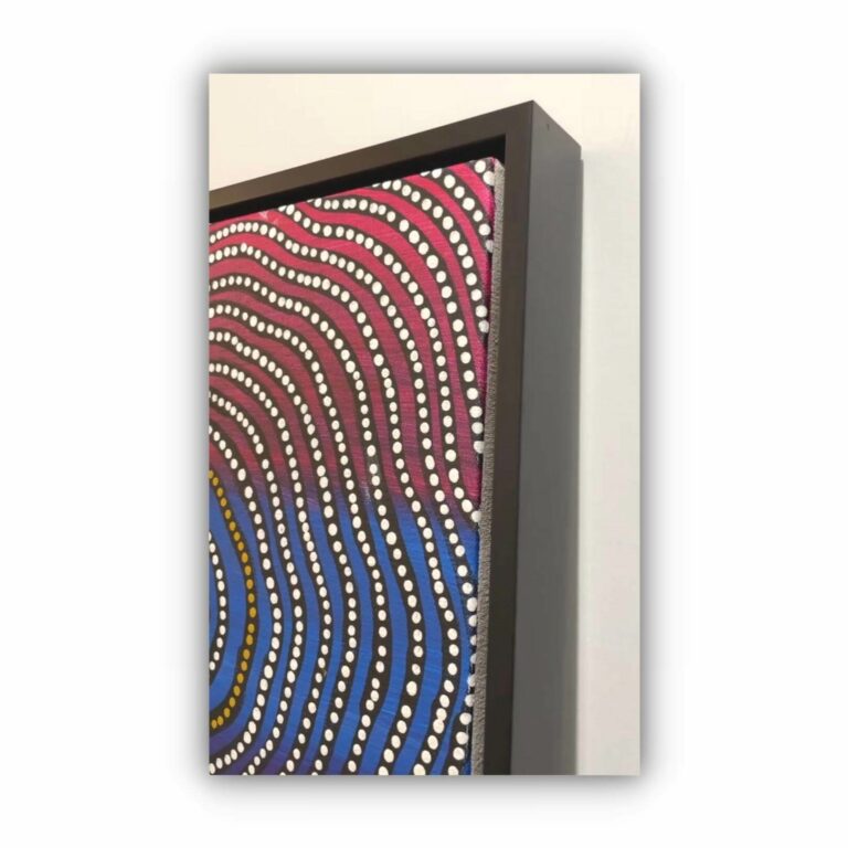 red and blue aboriginal painting in black frame
